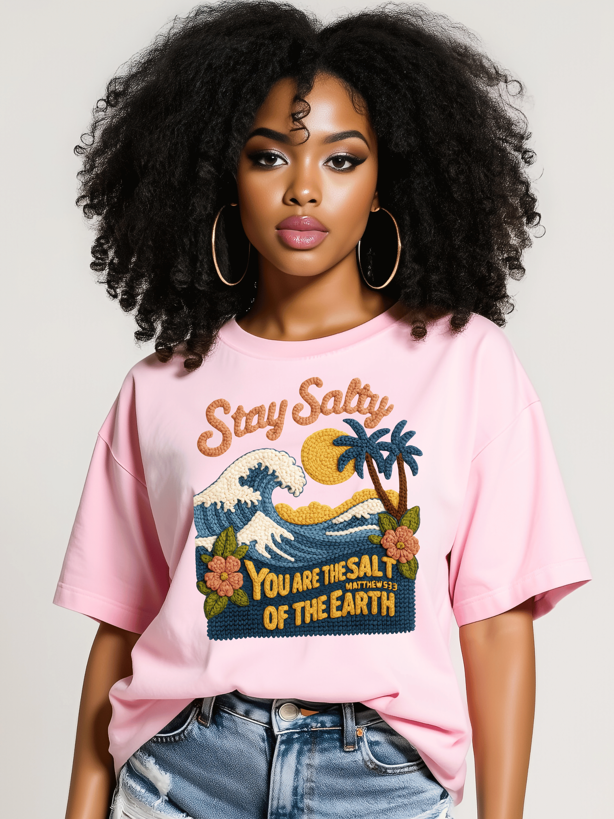 Person wearing a pink t-shirt with a graphic design and text.