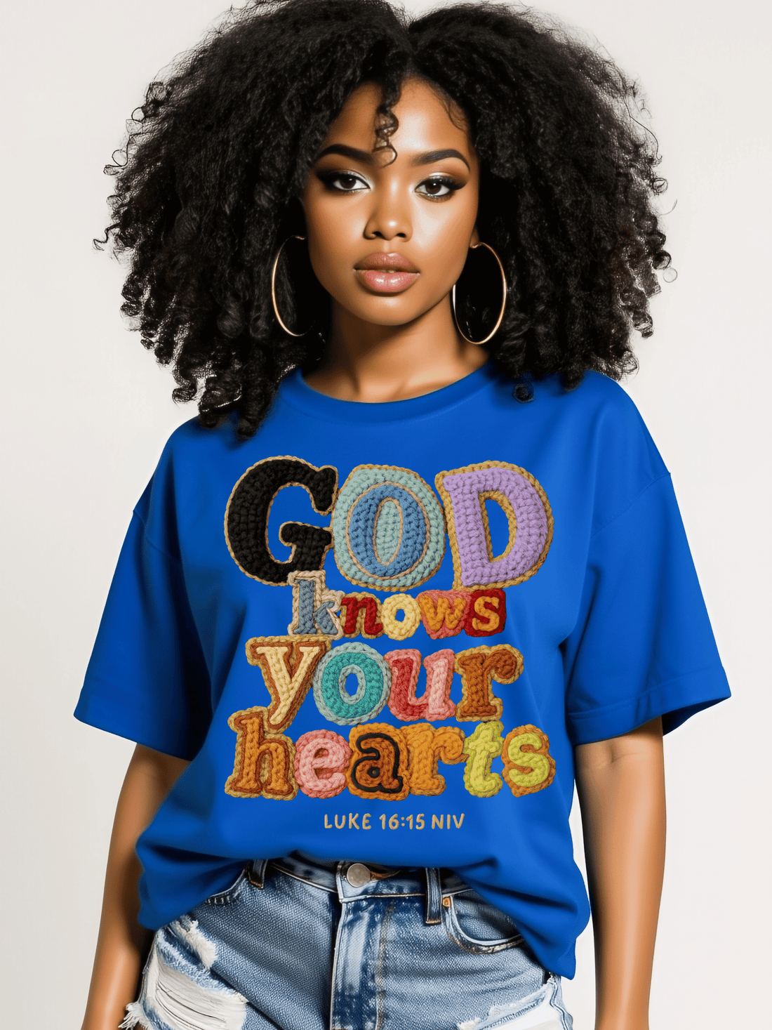 Woman wearing a blue t-shirt with colorful text design on a plain background