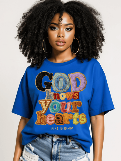 Woman wearing a blue t-shirt with colorful text design on a plain background