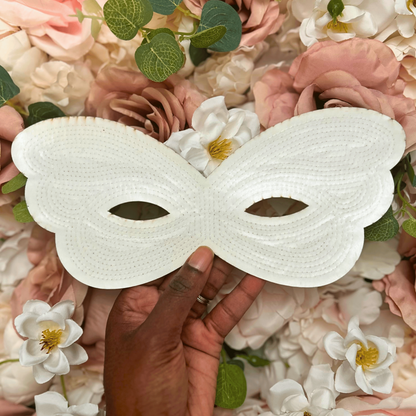 White mask held over a floral background