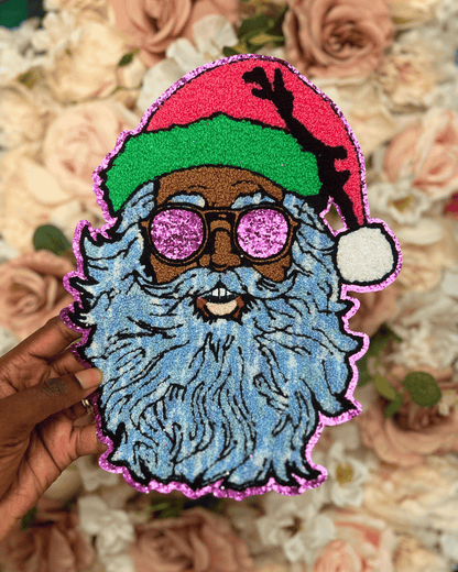 Colorful patch of a bearded figure with glasses and a red hat held over a floral background