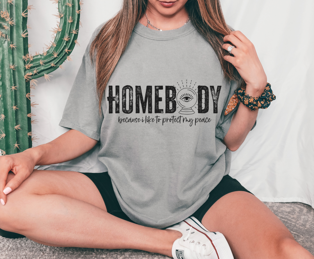 Homebody design printed on soft cotton tee and sweatshirt, featuring motivational graphic tee